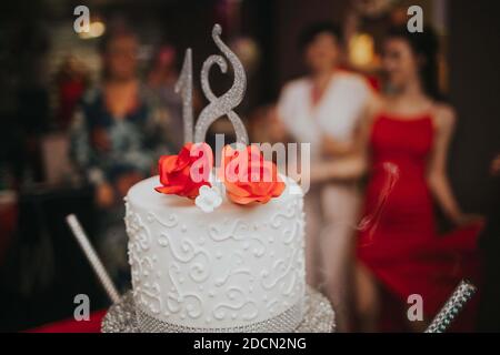 Eine Nahaufnahme der weißen schönen Torte für einen 18 Geburtstag bei der Geburtstagsfeier Stockfoto