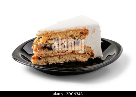 Stück Biskuitkuchen auf schwarzer Porzellanuntertasse Stockfoto