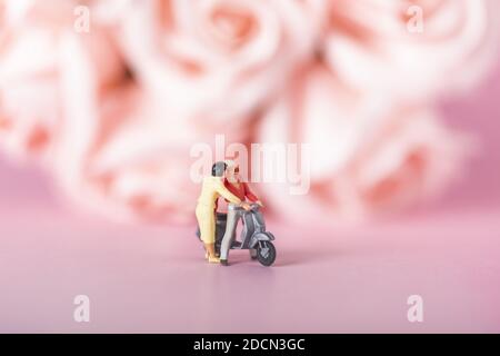 Nahaufnahme eines Paares auf Moped-Figuren auf Pink Hintergrund Stockfoto