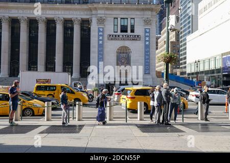 NEW YORK - 24. Oktober 2020: Die Leute warten am Madison Square Garden auf den ersten Tag der frühen Abstimmung. Blick vom 8. Ave entlang des Taxistandes. Stockfoto