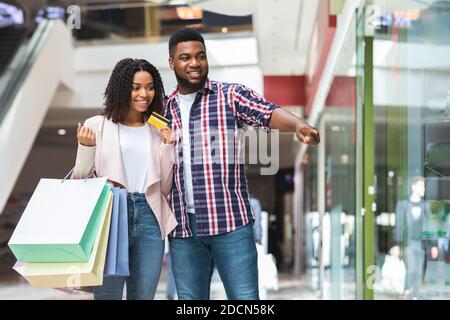 Paar Auf Shopping. Positive Schwarze Ehegatten, Die Zusammen Im Kaufhaus Einkaufen Stockfoto