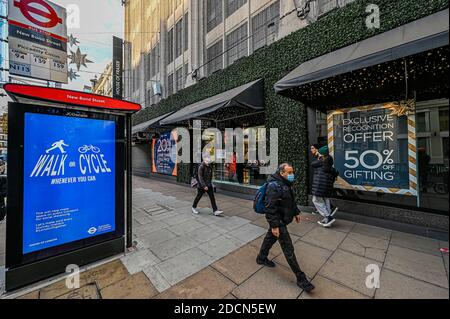 London, Großbritannien. November 2020. House of Fraser bietet Rabatte auf alles, während Bushaltestellen-Nachrichten covid Sicherheitsverfahren fördern - geschlossene Einzelhändler tun ihr Bestes, um Black Friday und Weihnachten Verkäufe zu fördern. Trotz der neuen Sperre, die jetzt in Kraft ist, sind die Menschen immer noch im Zentrum londons. Die Weihnachtsbeleuchtung ist an, aber die Geschäfte sind geschlossen. Viele Menschen tragen Masken, auch draußen. Kredit: Guy Bell/Alamy Live Nachrichten Stockfoto