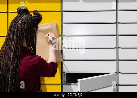 Er sucht geistig nach der genauen Korrespondenzadresse. Er schreibt mit einem weißen Stift auf einen Umschlag. Schreibt den Adressaten. Stockfoto