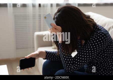 Close up unglücklich asiatische Frau hält Plastikkarte und Telefon Stockfoto