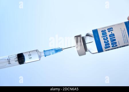 Spritze, die eine covid 19 Coronavirus-Impfdosis zur Injektion aus der Fläschchenflasche nimmt. Stockfoto