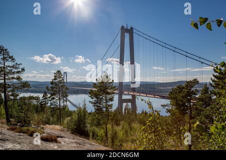 Höga Kustenbron, eine Hängebrücke über den Fluss Ångermanälven unter blauem, sonnigem Himmel bei Veda, Schweden. Stockfoto