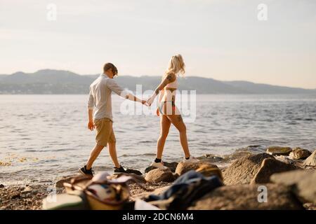 Frau Hält Hände Zu Fuß Mit Freund Auf Felsen Stockfoto