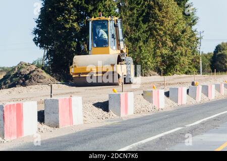 Schwingende Boden Verdichter arbeiten auf der Autobahn Baustelle Stockfoto