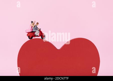 Nahaufnahme eines Paares auf Moped-Figuren Ein rotes Herz Stockfoto