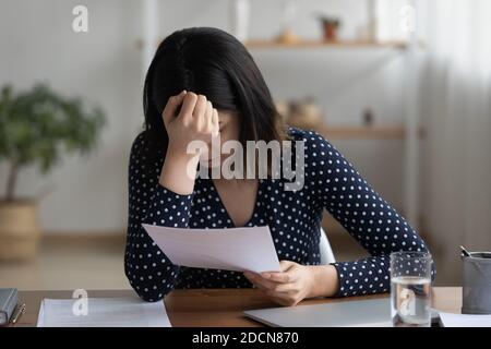 Nahaufnahme frustriert asiatische Frau lesen schlechte Nachrichten in Brief Stockfoto