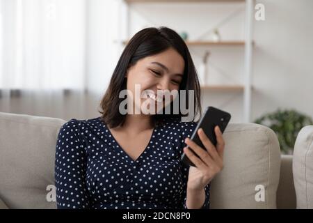 Nahaufnahme lächelnde asiatische junge Frau Blick auf Telefonbildschirm Stockfoto