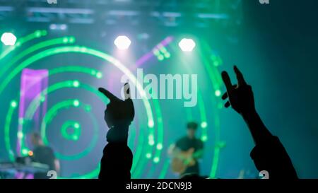 Man Silhouette beim Rockkonzert vor der Bühne mit Grünlicht Stockfoto