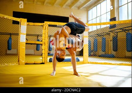 Zwei männliche MMA-Kämpfer kämpfen in einem Käfig Stockfoto