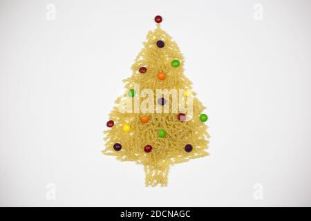 Weihnachts- und Neujahrsbaum aus Nudelbonbons auf weißem Hintergrund, Freiraum für Text - Feiertage, Winter, das Konzept von Weihnachten und Neujahr Stockfoto