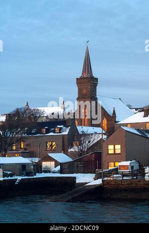 Wintersonnengang spiegelt sich in Fenstern aus traditionellem schottischem Stein wider Häuser auf Orkney Stockfoto