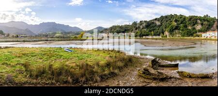 Ein Blick auf die Mündung der Sella in Asturien bei Ebbe mit alten Ruderboot Wracks Stockfoto