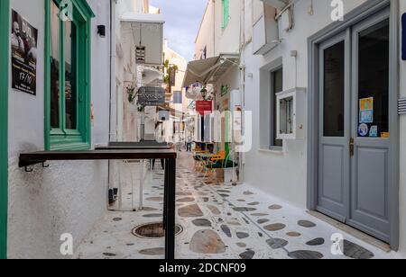 Tinos / Griechenland - Oktober 17 2020: Weiß getünchte Häuser und gepflasterte Gasse in Chora von Tinos, einer griechischen Insel in der Ägäis. Stockfoto