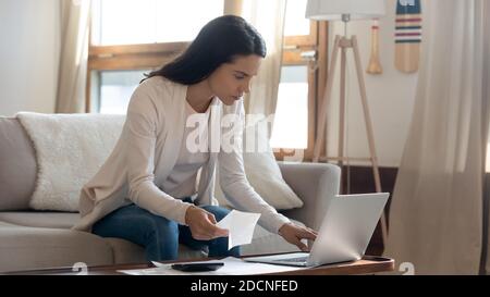 Nachdenkliche junge Geschäftsfrau Girokonto online vom Heimbüro Stockfoto