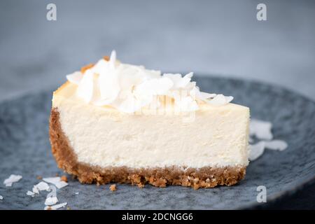 Scheibe veganer Kokoskäke auf einem Teller. Kokosnuss Cashew Käsekuchen Stockfoto