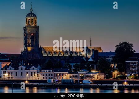 Abenddämmerung lange Belichtung der Uferpromenade in Deventer, Niederlande, mit IJssel und St. Lebuinus Kirche. Stockfoto