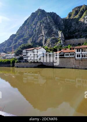 Historische Amasya Häuser am Ufer des Kizlrmak Flusses und Kralkaya (König Felsgräber) Friedhöfe auf der Rückseite. Stockfoto