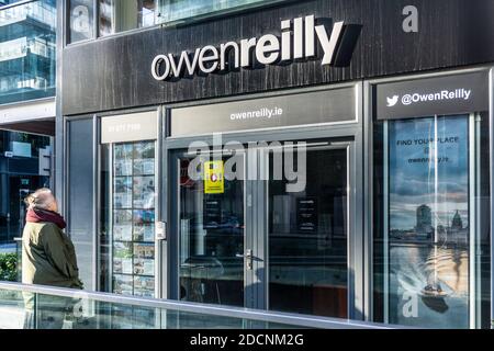 Immobilien zu verkaufen.EINE Frau studiert die Preise eines Hauses bei einem Immobilienmakler in Forbes Street in Grand Canal Dock in Dublin, Irland. Stockfoto