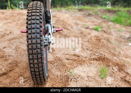 Rutschfeste Lauffläche auf Motorradreifen, Motocross-Bike in sandiger Spur, Rückansicht, Copyspace Stockfoto