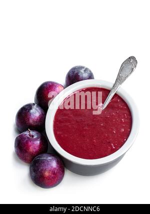 Hausgemachtes Chutney aus Pflaumen in Tonschüssel isoliert auf weiß Stockfoto