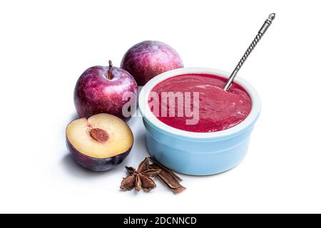 Hausgemachtes Chutney aus Pflaumen und Gewürzen in Tonschüssel isoliert Auf Weiß Stockfoto