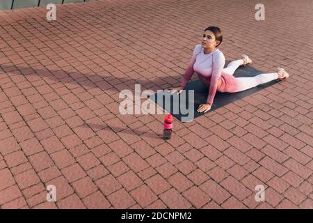 Sportlerin steht in Cobra Stretch-Übungspose Stockfoto