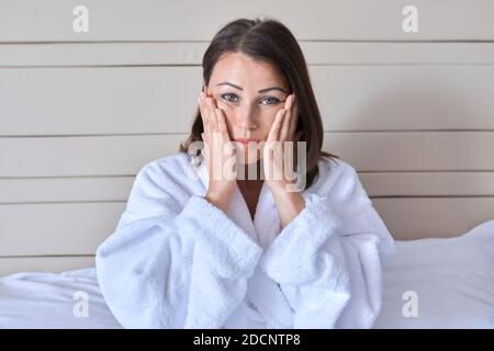 Frau mittleren Alters tut Gesichtsmassage, Alter Schönheit und Gesichtshaut Pflege Stockfoto