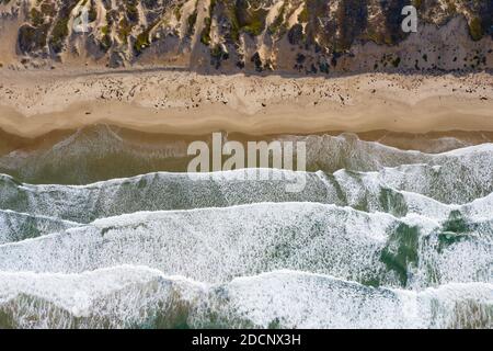 Der Pazifische Ozean wäscht sich an einen Strand und Sanddünen in Morro Bay, Kalifornien. Dieser Küstenabschnitt von Zentralkalifornien ist für seine Landschaft bekannt. Stockfoto