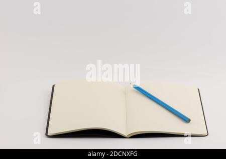 Nahaufnahme eines offenen leeren Buches mit Blau Farbstift isoliert auf weißem Hintergrund Stockfoto