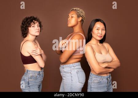 Gruppe von jungen schönen Frauen in Tanktops und blaue Jeans In Reihe stehend Stockfoto