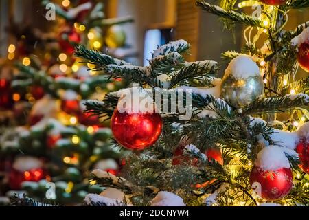 Weihnachtsbaum Zweig unter dem Schnee mit roten Ballons Stockfoto