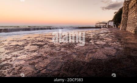 Wawes am alten Teil des Passetto Strandes in Ancona Stadt bei Sonnenuntergang im Winter Stockfoto