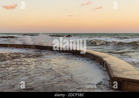 Wawes am alten Teil des Passetto Strandes in Ancona Stadt bei Sonnenuntergang im Winter Stockfoto