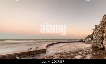 Wawes am alten Teil des Passetto Strandes in Ancona Stadt bei Sonnenuntergang im Winter Stockfoto