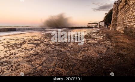 Wawes am alten Teil des Passetto Strandes in Ancona Stadt bei Sonnenuntergang im Winter Stockfoto