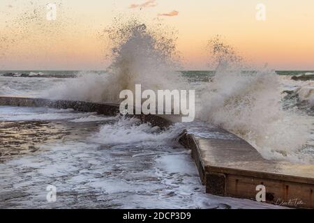 Wawes am alten Teil des Passetto Strandes in Ancona Stadt bei Sonnenuntergang im Winter Stockfoto