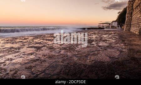 Wawes am alten Teil des Passetto Strandes in Ancona Stadt bei Sonnenuntergang im Winter Stockfoto