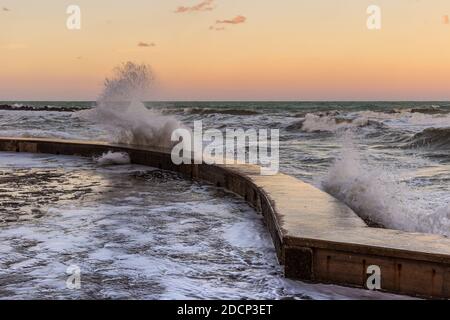 Wawes am alten Teil des Passetto Strandes in Ancona Stadt bei Sonnenuntergang im Winter Stockfoto