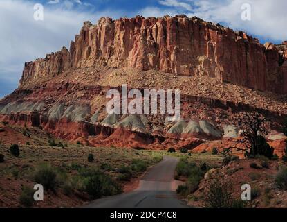 Blick auf EINE farbenfrohe Butte A von der Scenic Drive Road Capitol Reef National Park an EINEM sonnigen Sommertag mit Ein klarer blauer Himmel und EIN paar Wolken Stockfoto