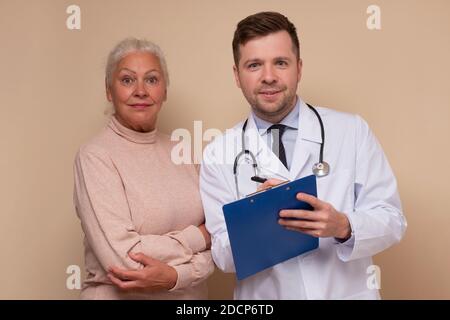 Männlicher kaukasischer Arzt im Gespräch mit seinem älteren Patienten Stockfoto