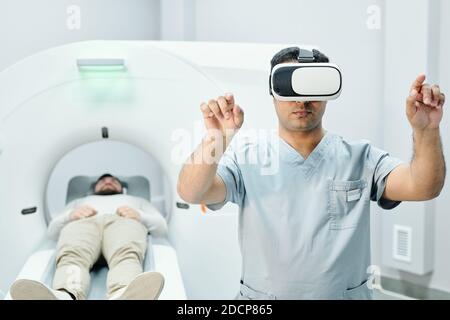 Moderne Mixed-Race männlichen Arzt in medizinischen Uniform und vr Headset Stockfoto
