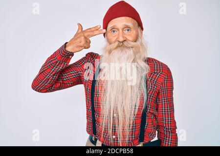 Alter älterer Mann mit grauen Haaren und langem Bart tragen Hipster-Look mit Wollmütze Schießen und Töten sich zeigend Hand und Finger zum Kopf wie gu Stockfoto