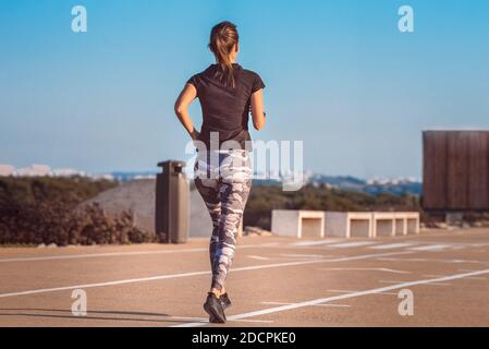 Junge Fitness-Frau Läuferin läuft auf der Straße. Fitness und Workout Wellness Konzept Stockfoto