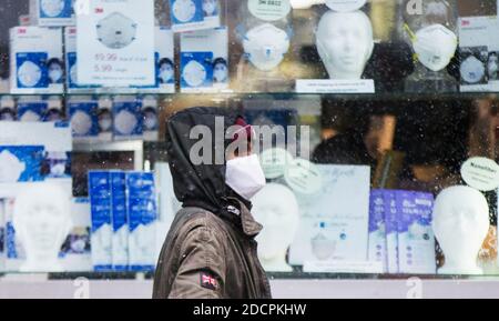 Toronto, Kanada. November 2020. Ein Mann mit einer Gesichtsmaske geht am 22. November 2020 an einem Geschäft vorbei, das Gesichtsmasken verkauft. Laut CTV meldete Kanada am Sonntagabend insgesamt 330,503 Fälle und 11,455 Todesfälle. Quelle: Zou Zheng/Xinhua/Alamy Live News Stockfoto