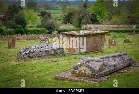 Rasenkrypten in einem alten Welt Pfarrfriedhof in St. Michael & All Angels Kirche blickt auf eine Landschaft der englischen Landschaft in East Coker, England Stockfoto