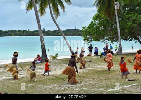 Einheimische melanesische Bewohner und Kinder führen einheimische Kanak-Tänze auf Kreuzfahrtschiffbesuchern in Kuto Bay, Isle of Pines, Neukaledonien auf. Stockfoto